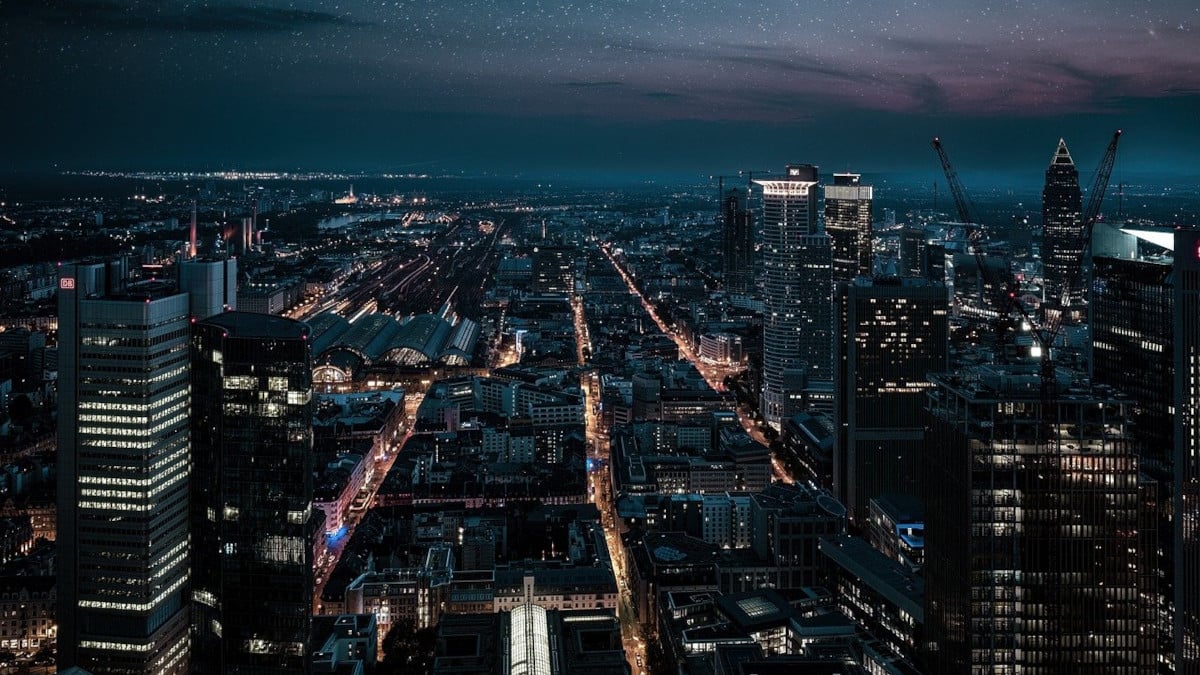 A city at night with some areas dark as widespread power outages from a recent disaster leave many residents and businesses without power.