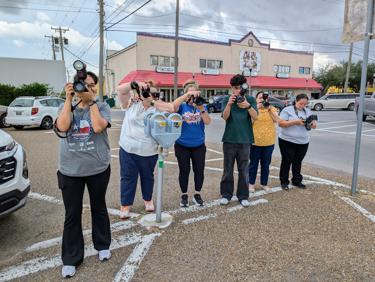 Photography students taking pictures as a group during live practice