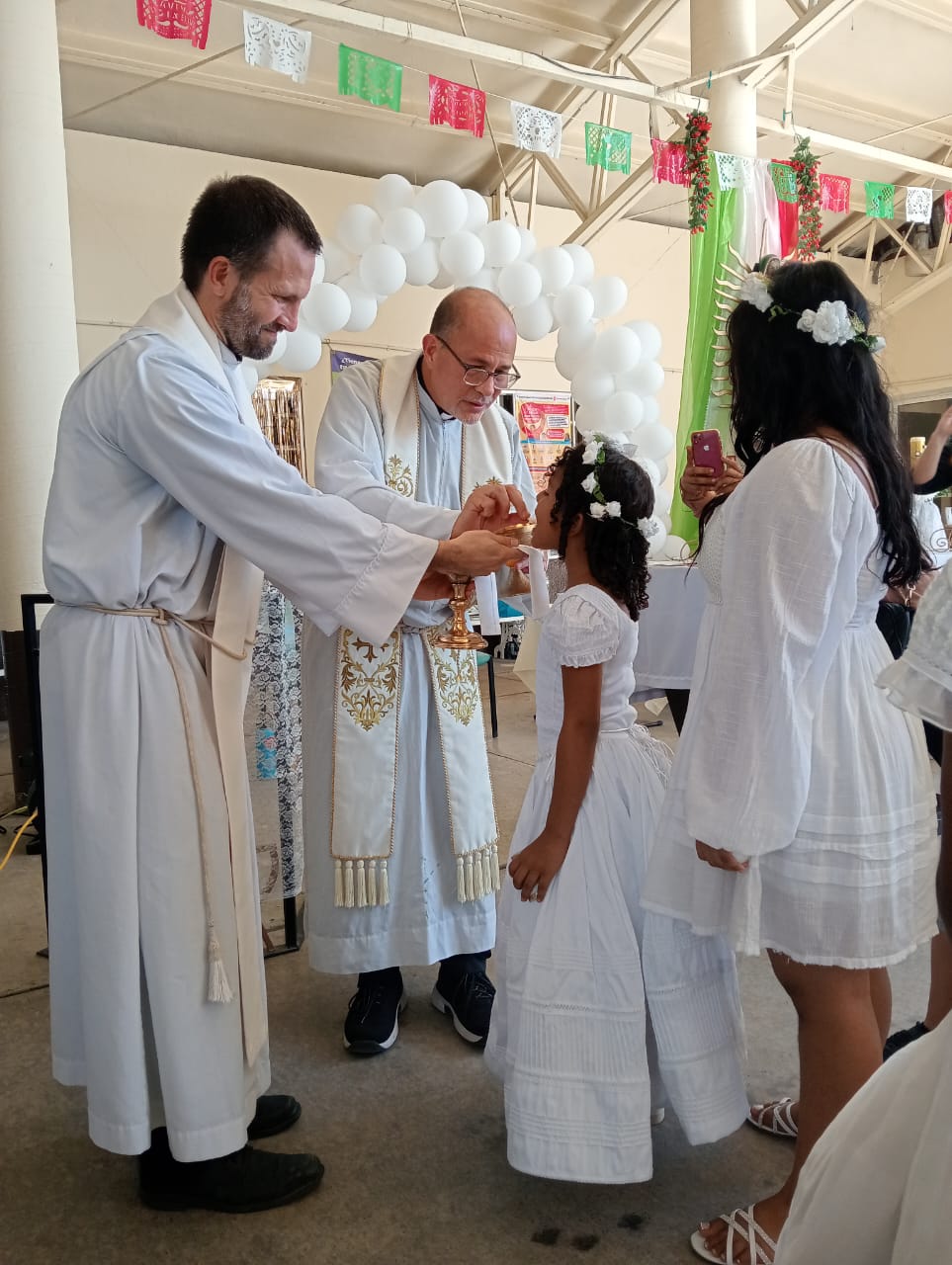 Fr. Flavio Bravo, SJ, and Fr. Brian Strassburger, SJ, distribute the Eucharist 