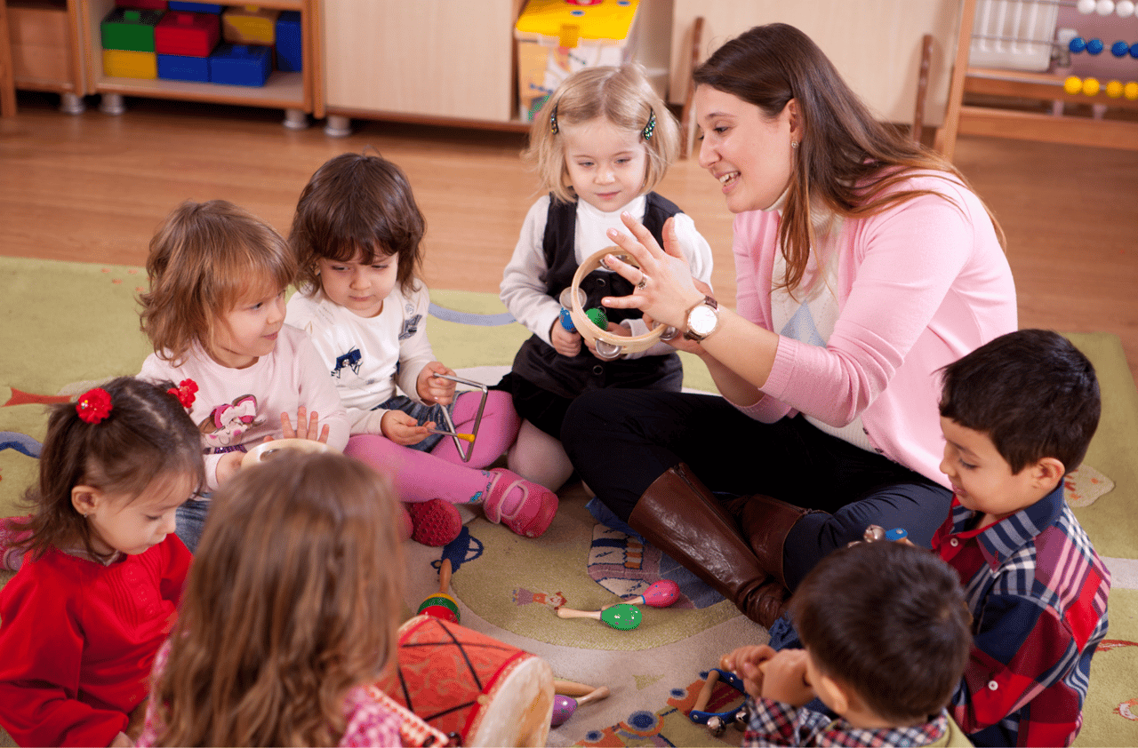 a preschool teacher speaking to a group of children