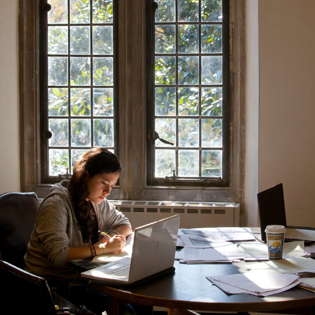 A person sits at a desk with papers strewn around them.