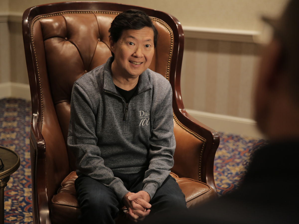Ken Jeong sits on a chair.