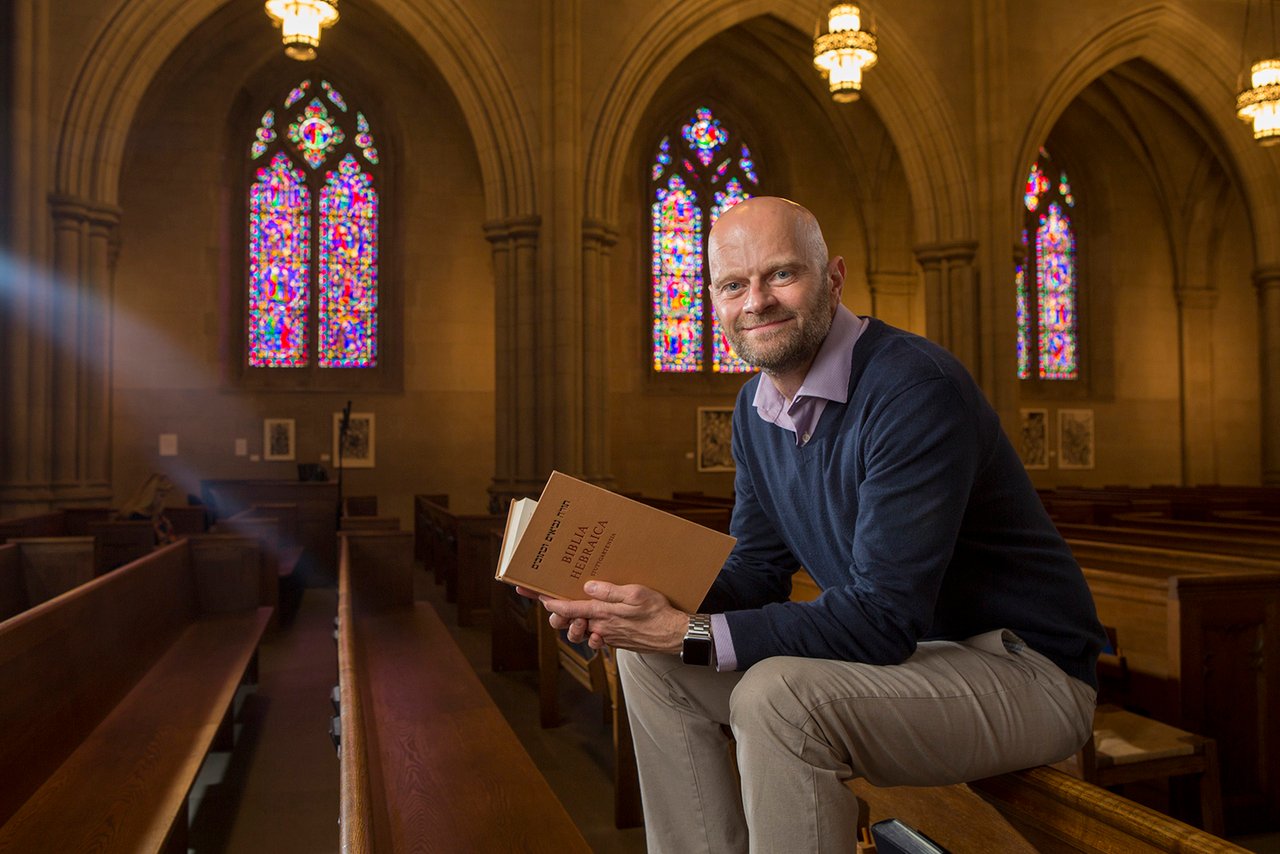 a person sitting in Duke Chapel holding a book