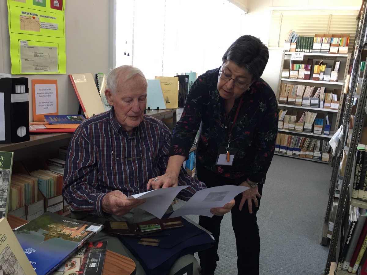 A library assistant helping one of our members with their research