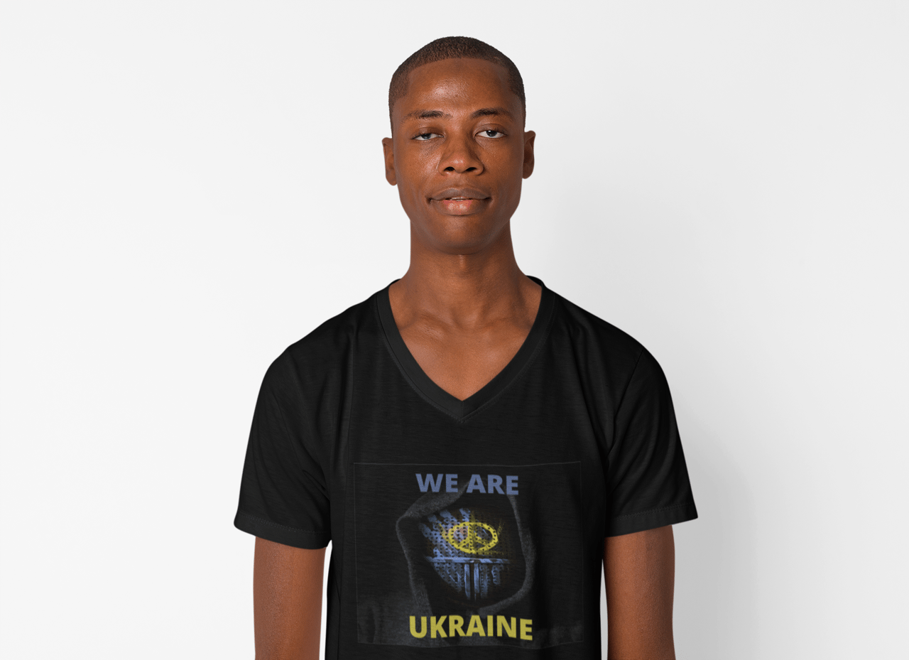 A man in a plain pose while wearing a v-neck tee.