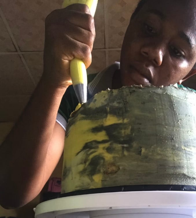 A chef in the bakery kitchen decorating cake 