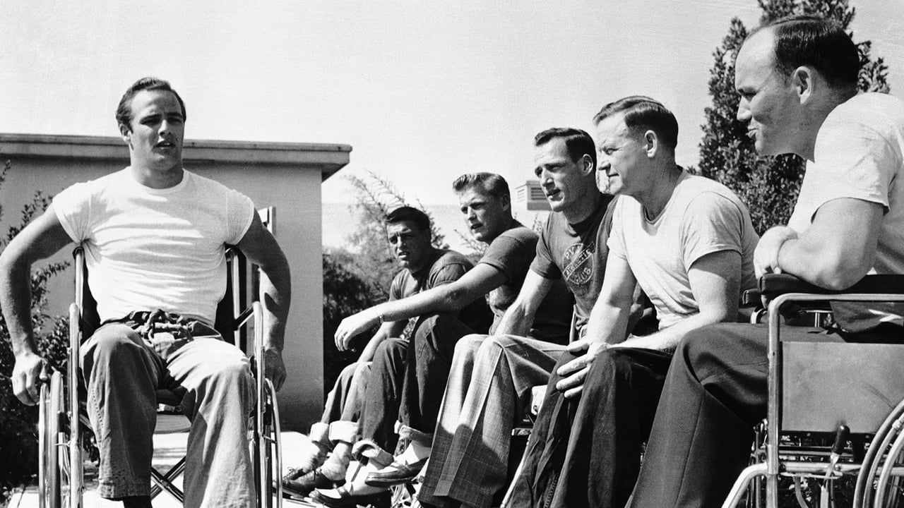 Marlon Brando in a wheelchair in the movie "The Men" in front of a line of other male wheelchair users.