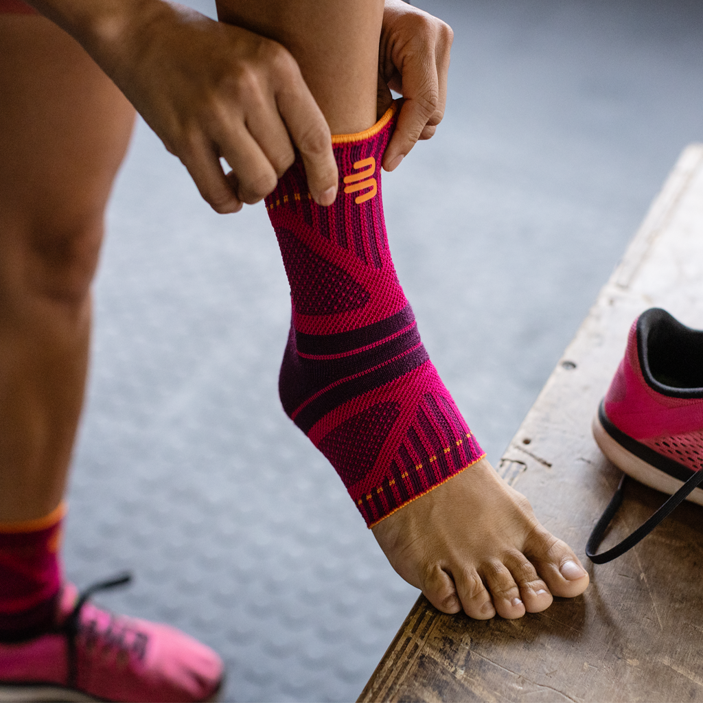 Woman putting on a pink ankle brace