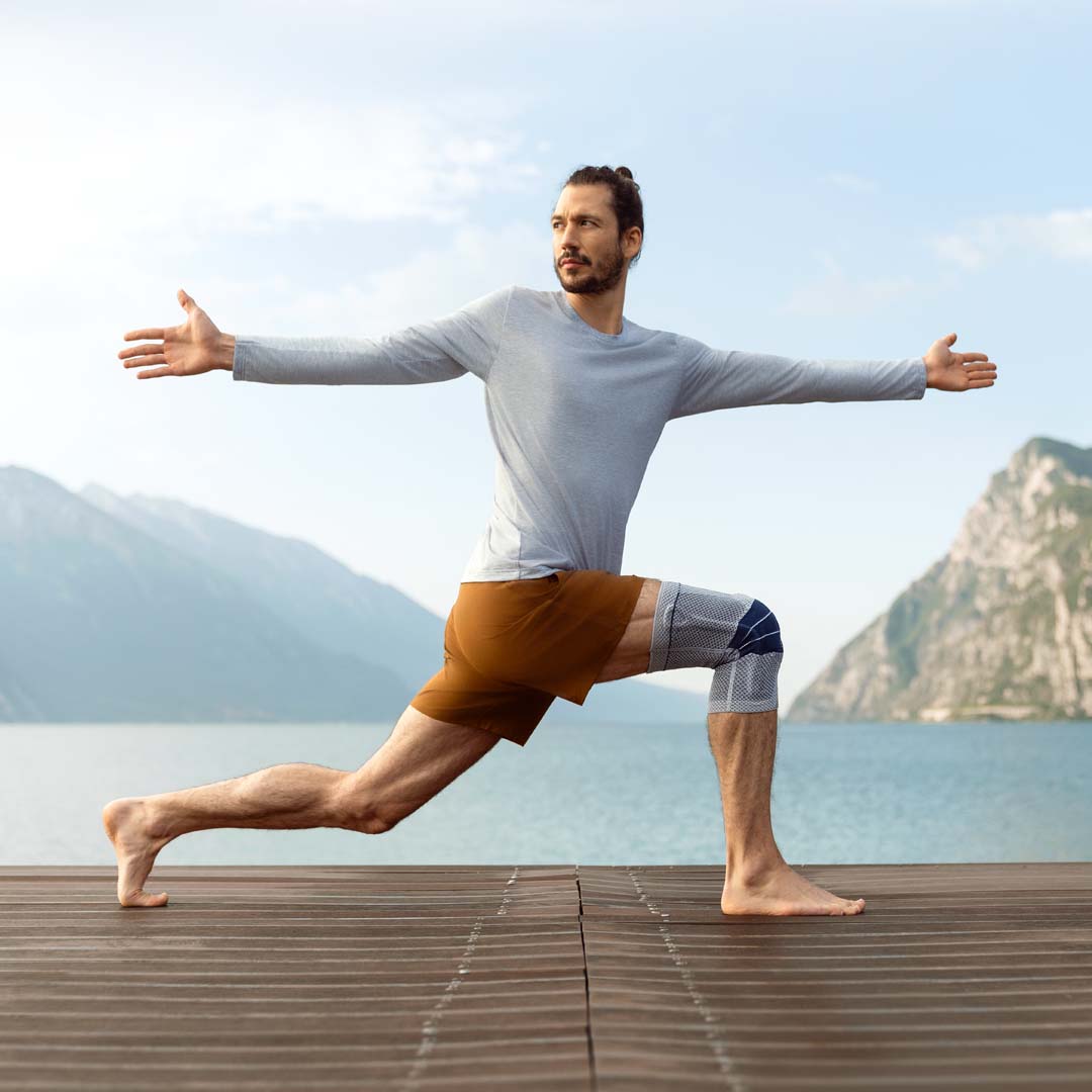 Man doing yoga wearing a knee brace