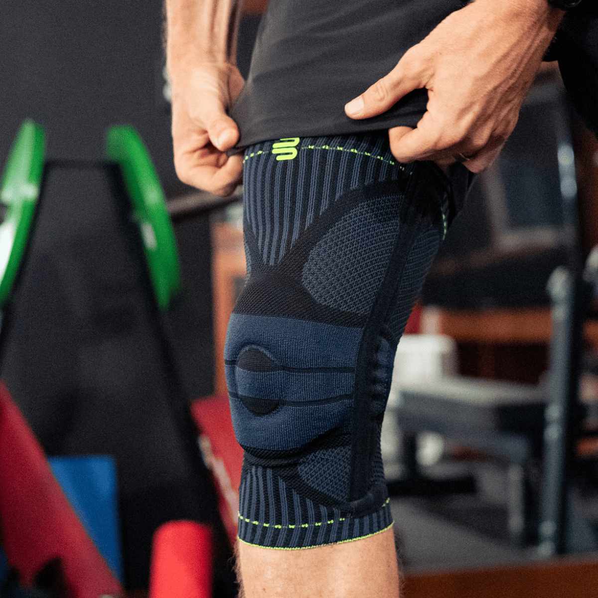 Man jumping over wall wearing sports knee supports