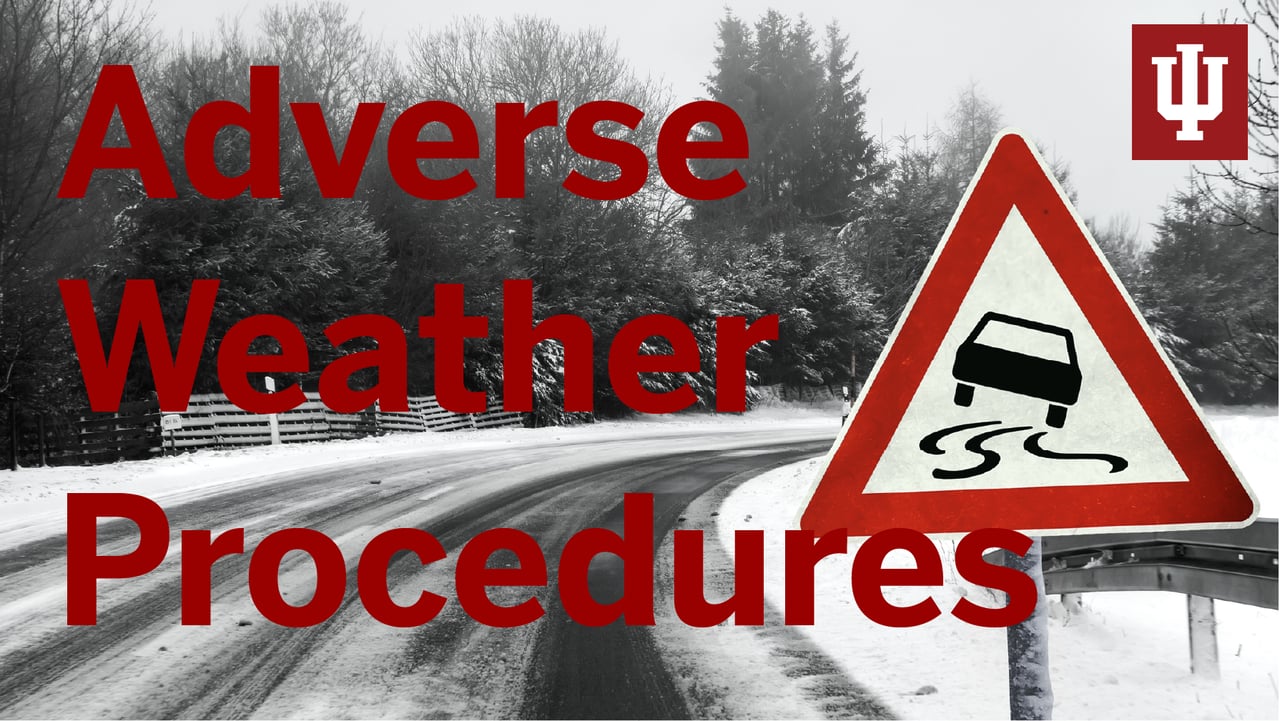 A snowy road with a warning sign of slippery lanes