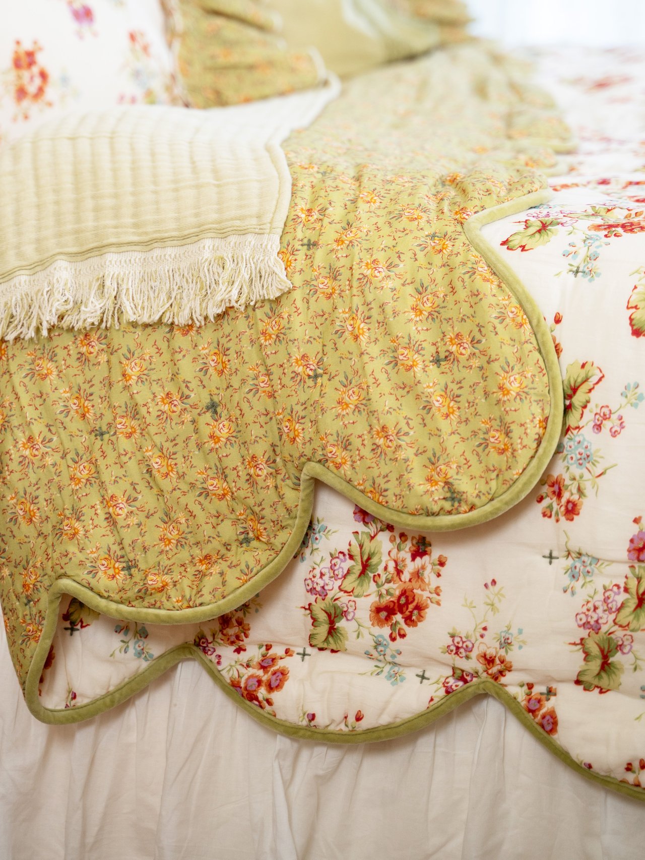 A closeup of a layered bedspread with lots of patterns and texture