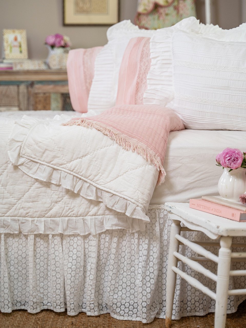 A closeup of a layered bedspread with pintucks and ruffles