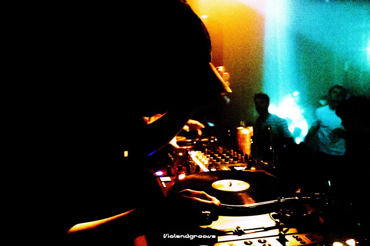 Dj playing vinyl records at a rave.