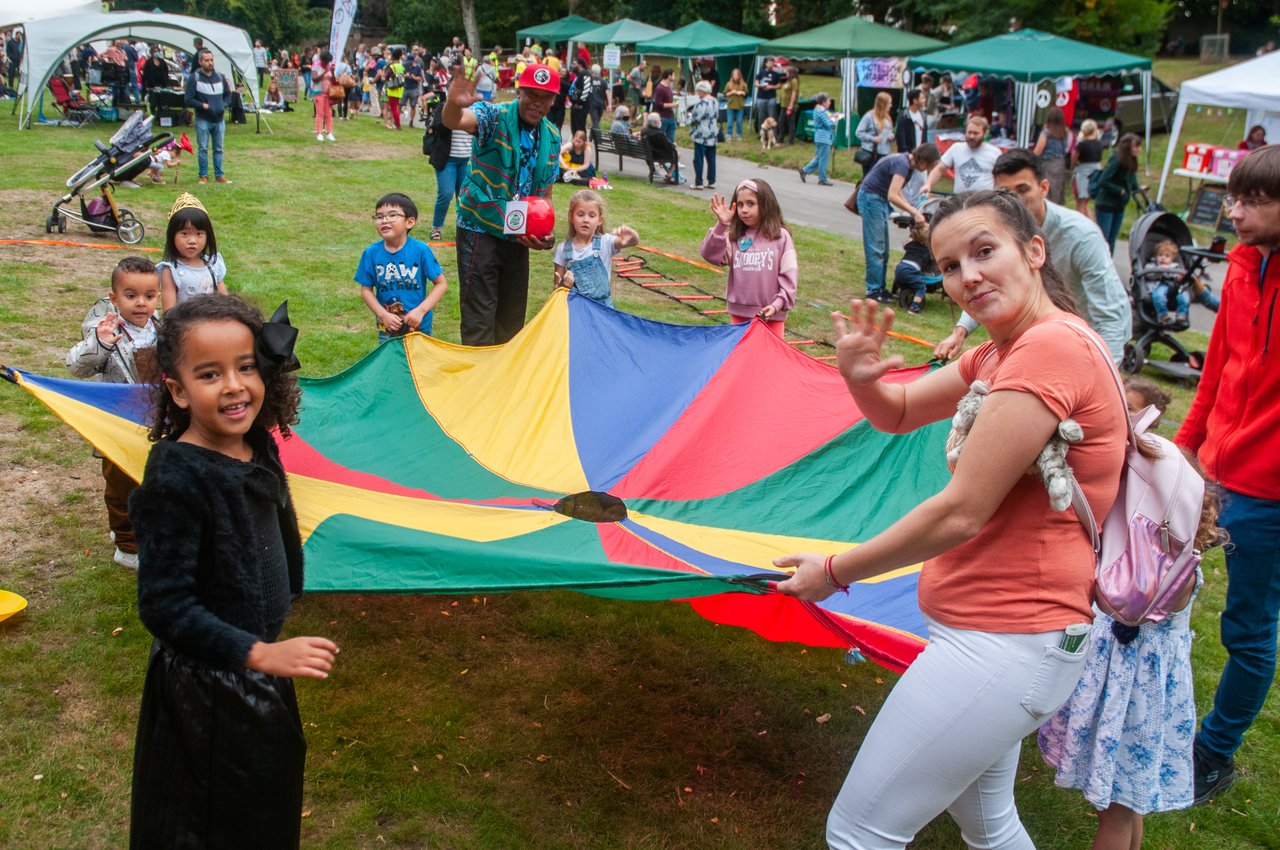 A group of children holding onto a play parachute at Nottingham Green Festival