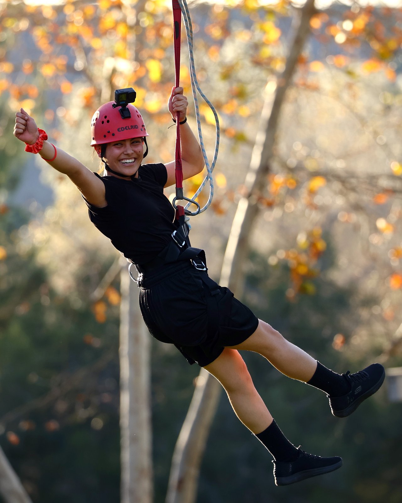 Teenage girl rides zipline at ropes course while attending Sunburst Youth Academy.
