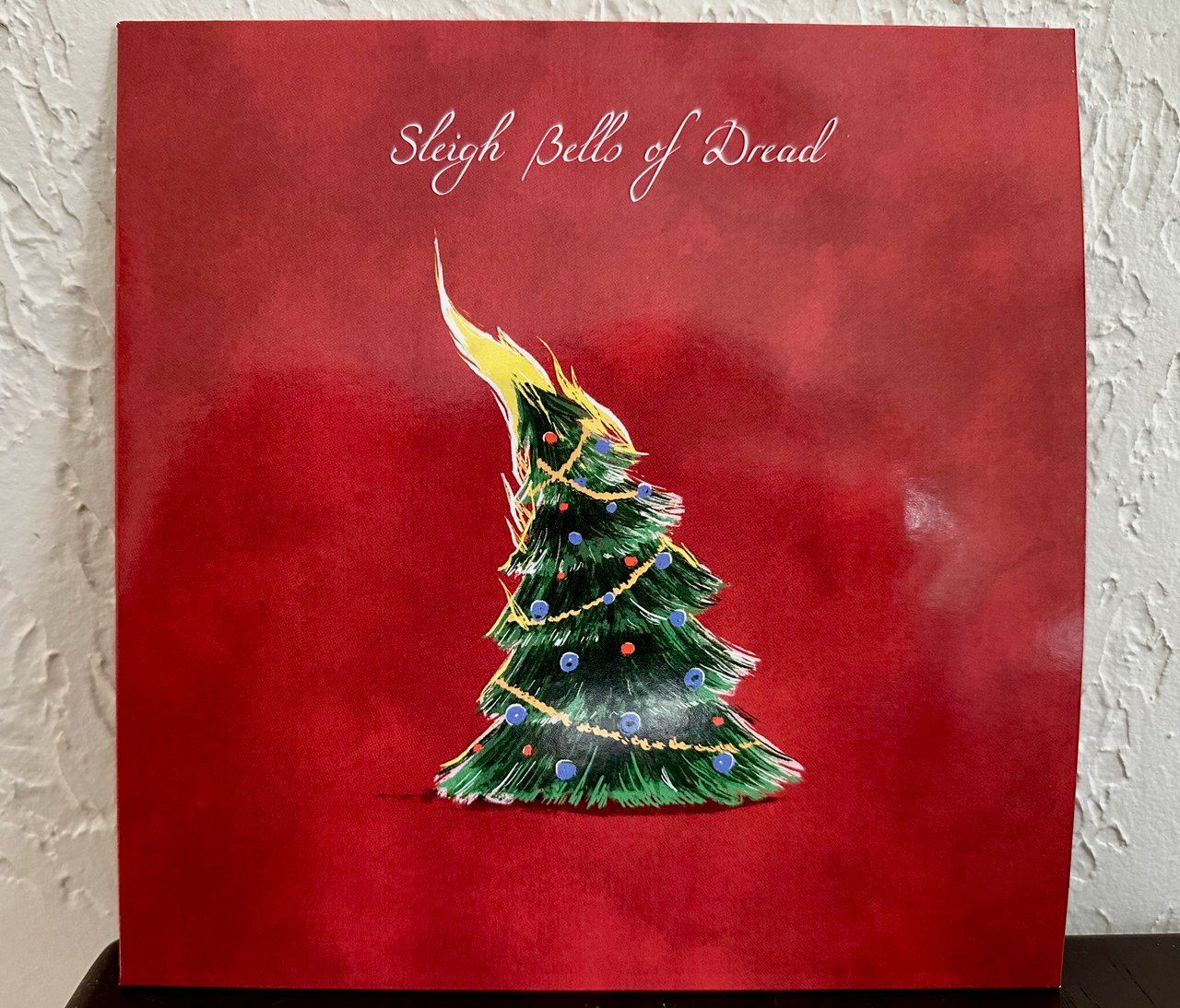 Album cover: A burning pine tree against a red background