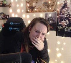 Siryn crying into her hand reacting to a video game