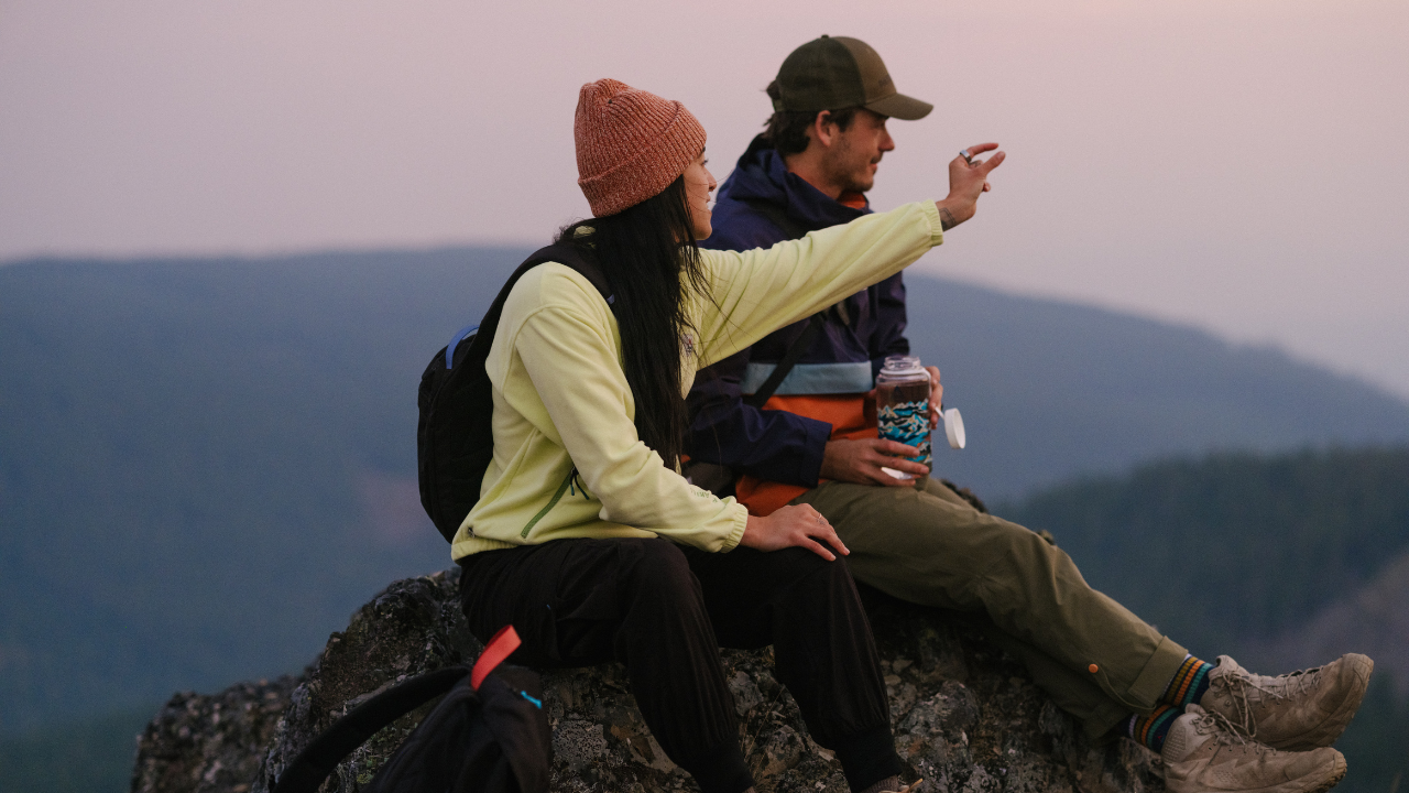 4 people silhoutted against a purple and grey mountain sky