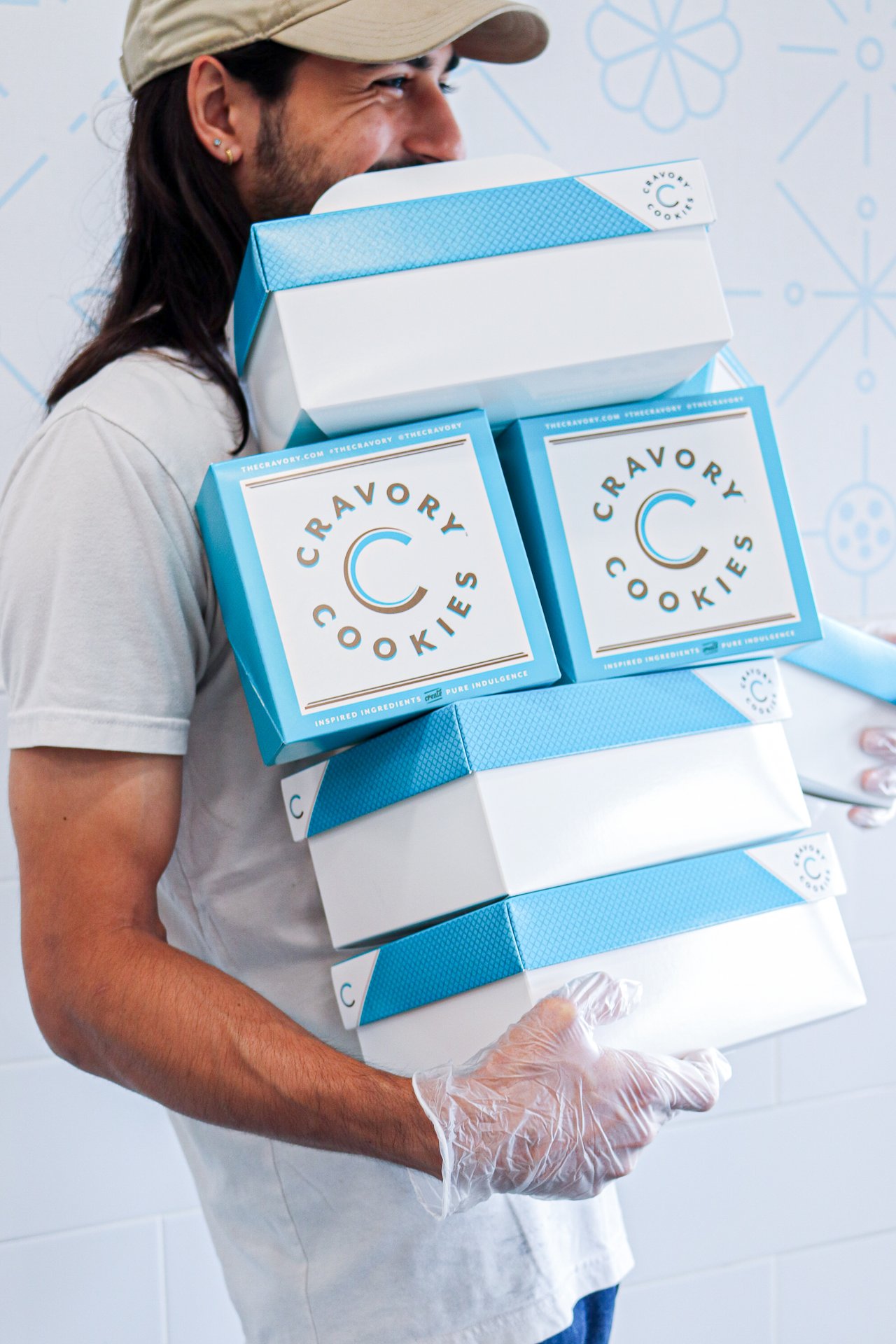 employee holding Cravory cookie boxes in a cravory store