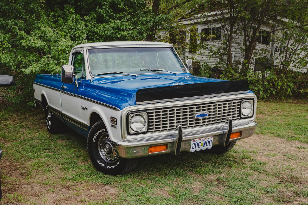 1971 chevy pickup truck in front of trees, truck is painted blue and white. 