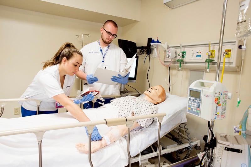 Nursing students working with manikin