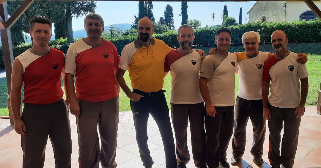This is a group photo of WingTsun International Stage in Guasticce 2023.The two men in yellow are GrandMaster K.Kernspecht and GrandMaster G.Schembri, the man at the left is Sifu Eric di Bene.