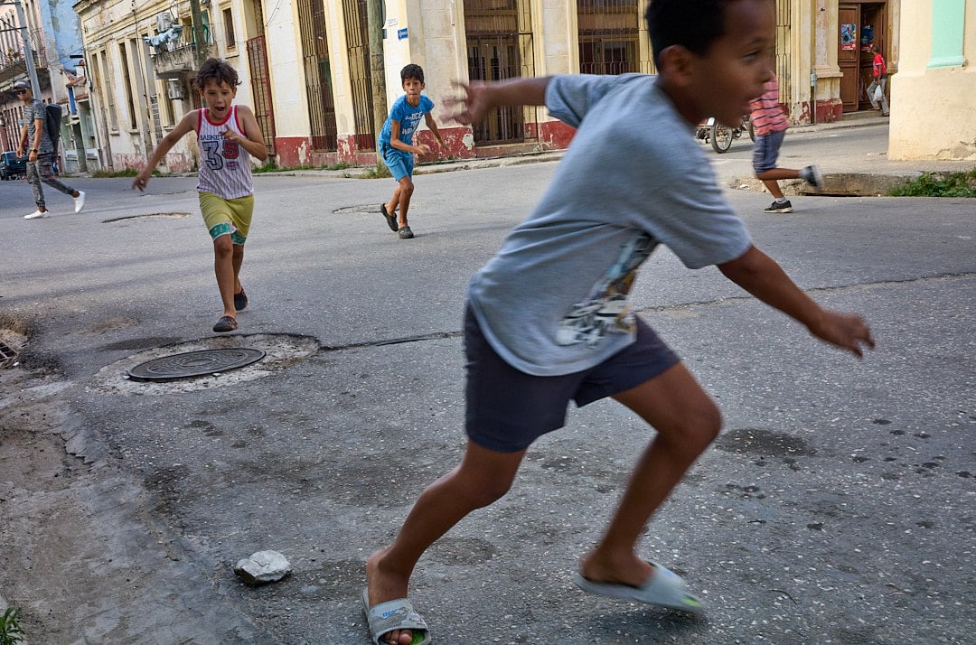 In a quiet Havana street, children play baseball without gloves and makeshift bases. The city becomes their feild...