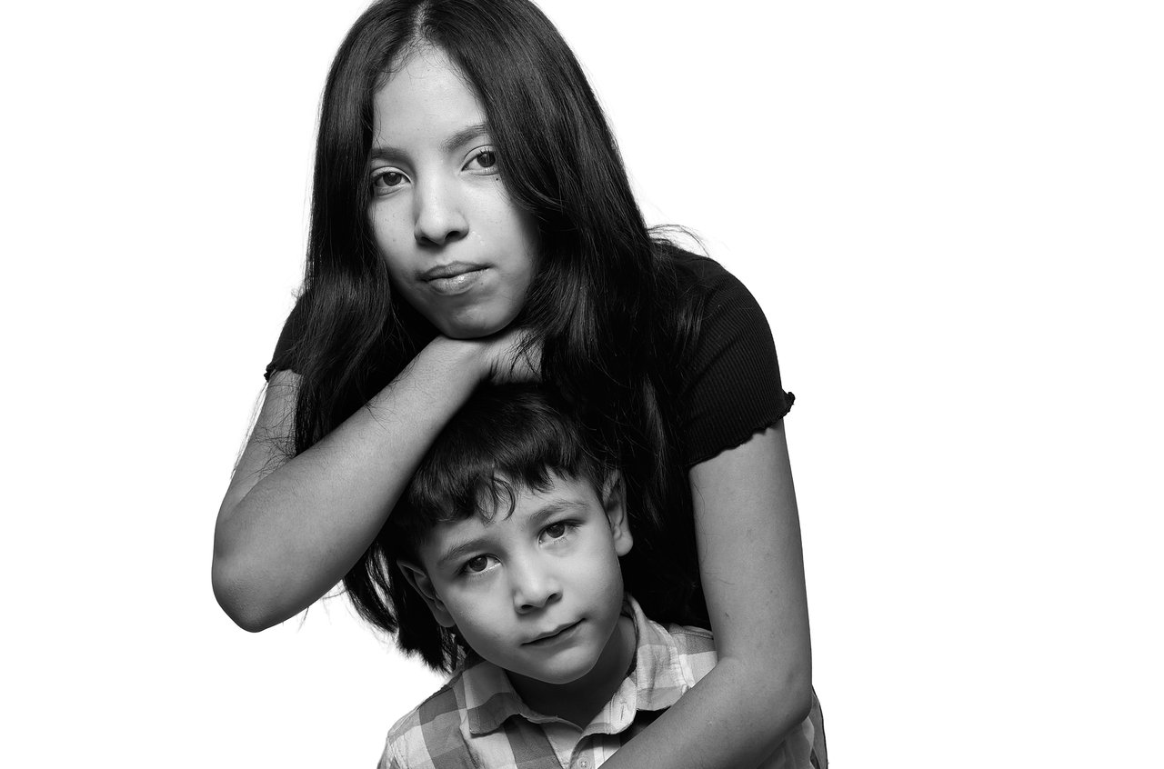 Black-and-white portrait of a sister holding her younger brother