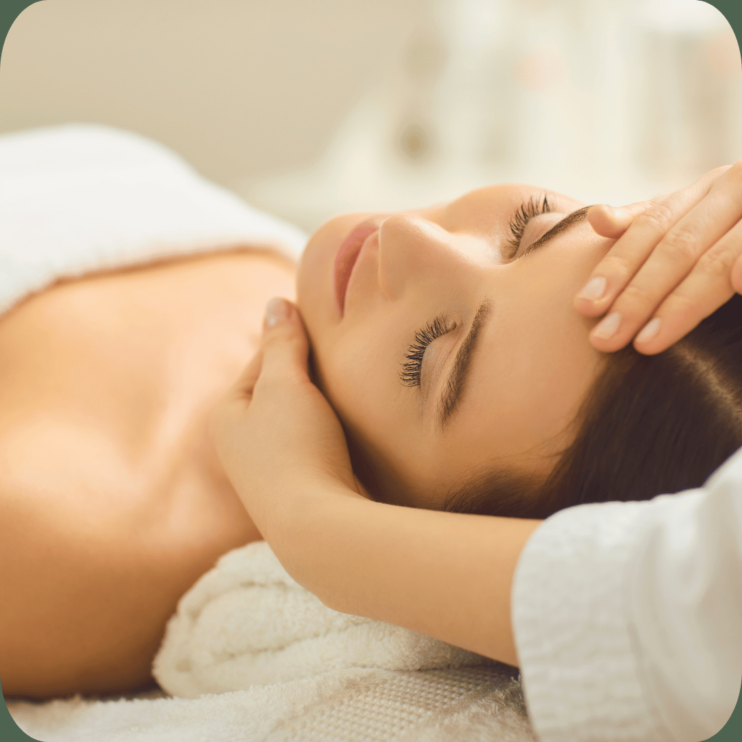 Woman receiving a calming head and face massage at a luxury spa for stress relief and relaxation.