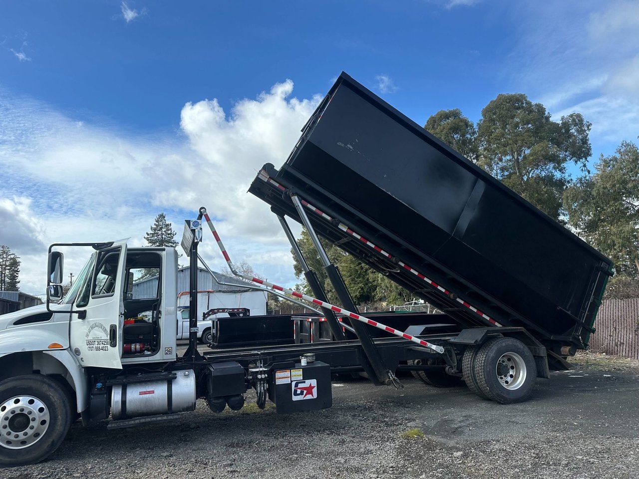 a person's cut off arm and hand holding an orange and black vinyl with the album cover showing on the left