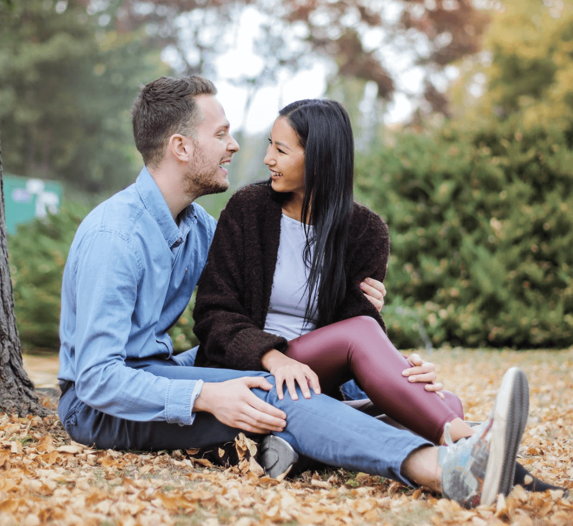 Laura and James sharing a cute moment in the fall in a forest