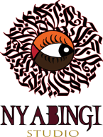 Alexoo pictured from the shoulders up under neon blue and organge lights. They wear a pair of black sunglasses