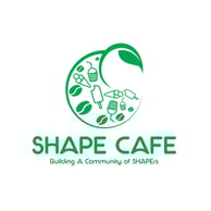 A young woman with brown hair and brown eyes in a coffee shop, smiling with a cup of milkshake