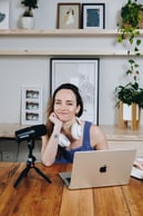 Photo of kirsti lang with computer and podcast mic