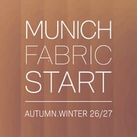 Alexoo pictured from the shoulders up under neon blue and organge lights. They wear a pair of black sunglasses