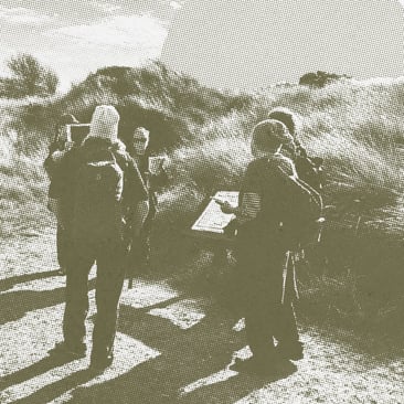 Olive-toned halftone photo of hikers with backpacks reading a map on an open hillside path.